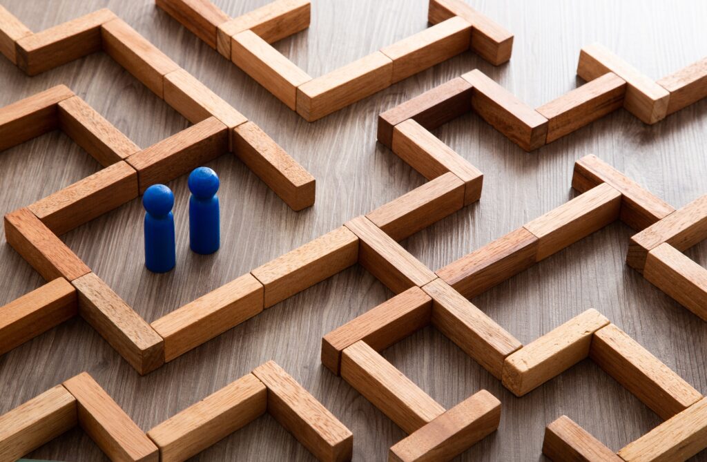 Wooden miniature at the start point of puzzle maze wood block. Leadership concept.